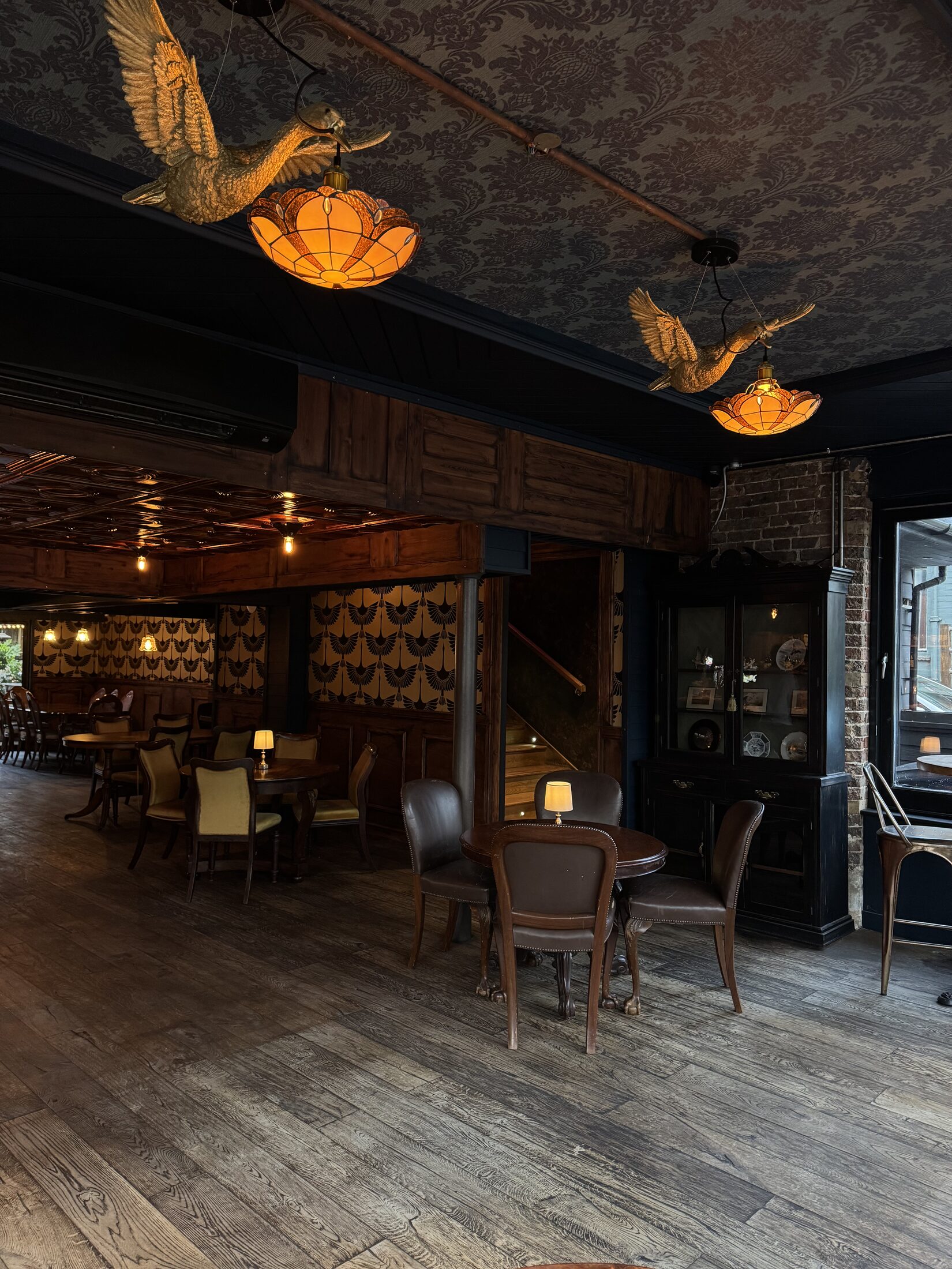Dining room with duck pendant lights and dark wood panelling